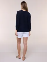 Buzo liviano de algodón con tejido de punto abierto y semi holgado, color beige, con escote bote, mangas largas de hombros caídos y costuras expuestas.