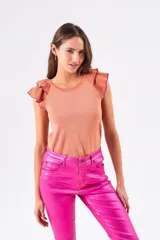 Top color salmón metalizado, de algodón peinado, con cuello redondo y mangas cortas con volados con borde fucsia.
