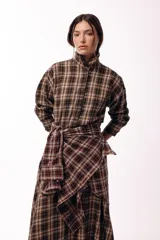 Camisa de corte recto y mangas largas con estampado de cuadros tartán en tonos marrones y beige. Presenta cuello camisero y cierre frontal con botones.