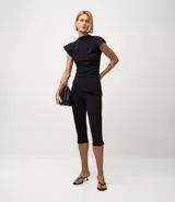 Pantalón capri negro de malla crepé, con pliegues delanteros y sin estampado.