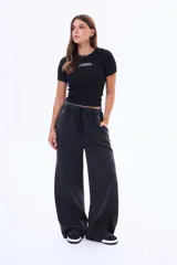 Remera negra de algodón con ajuste al cuerpo, manga corta y cuello redondo. Presenta un estampado frontal pequeño con el texto 'UPPER WEST SIDE, N.Y. NEW YORK BOOKS'.