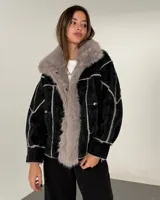 Campera tipo gamulán de cuero sintético negro con interior y solapas de piel sintética en color gris. Presenta costuras visibles y diseño de paneles.