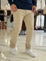 Pantalón de jean color beige, de corte recto y tiro estándar.