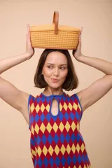 Vestido corto sin mangas con estampado de rombos en azul, rojo y amarillo. Tiene escote con forma de gota y terminación en picos.