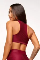 Top deportivo color bordó, con textura tipo panal 3D, cuello alto y estructura firme.