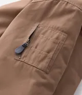 Campera bomber de sarga color tostado con cuello desmontable de pelo sintético oscuro. Presenta cierre frontal de cremallera, puños y cintura acanalados, y bolsillos laterales.
