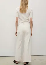 Jeans de tiro alto, corte culotte y pernera recta con bajo deshilachado. Confeccionados en tejido elástico de algodón estilo denim, cuentan con cierre de cremallera y botón, trabillas para cinturón y bolsillos traseros.