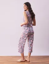 Conjunto de pijama marca René Rofé, compuesto por remera de mangas cortas con escote en V abotonado y pantalón capri con cintura elastizada. Diseño estampado con flores azules sobre fondo blanco.