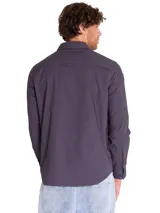 Camisa de manga larga Caterpillar, modelo Utility L/S Shirt, color gris oscuro. Cuenta con cierre frontal de botones, tres bolsillos de carga en el pecho con solapa y etiqueta con el logo de la marca.