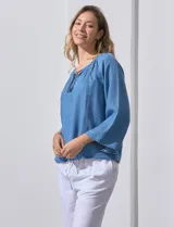 Blusa celeste de lyocell con cuello a la base y escote en V con lazo de ajuste. Manga larga amplia.