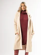 Tapado largo color camel confeccionado en lana escarada elastizada. Diseño clásico con cuello solapa y corte recto. Fabricado en Italia.