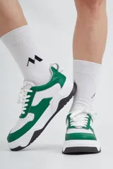 Zapatillas deportivas de cuero, combinadas en blanco y verde, con base negra.