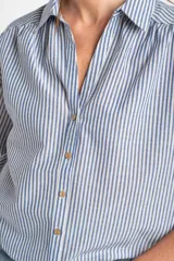 Camisa de manga corta con patrón de rayas verticales en tonos azul y blanco, cuello camisero y cierre frontal con botones.