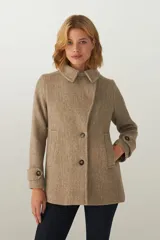 Chaquetón de lana fina sin teñir, con cuello clásico, cierre frontal de botones, bolsillos ojal y detalle de martingala en los puños. Incluye forro interior al tono.