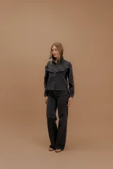 Jean de tiro alto con corte wide leg y pierna amplia, confeccionado en denim de tono azul oscuro con costuras a contratono.