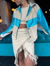 Camisa color beige con detalles en azul metalizado en mangas y pecho, y plateado en cuello y puños.