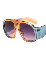 Lentes de sol con montura gruesa de acetato color gris y naranja, con lentes degradadas en marrón.