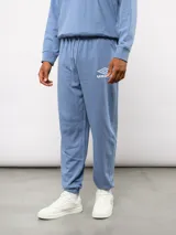 Pantalón jogger de felpa sin frisa, color gris claro melange, con logo bordado de Umbro en azul oscuro en el muslo izquierdo y puños elásticos en los tobillos.
