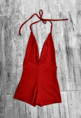 Mono corto de color rojo, con escote halter y espalda descubierta.