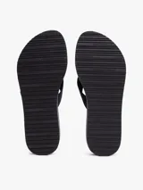 Ojotas de cuña de altura media, color azul marino, con tiras anchas de tejido trenzado y una pequeña insignia dorada con el monograma TH en la tira del dedo. La plataforma tiene un diseño de rayas blancas y un patrón de cadenas blancas.