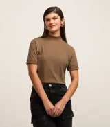 Remera color marrón confeccionada en malla de algodón, de corte amplio, con cuello alto en punto roma y mangas cortas con dobladillo.