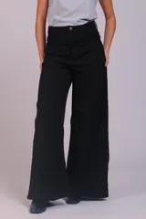 Pantalón de corte wide leg confeccionado en pana acanalada color marrón chocolate. Presenta tiro alto, cierre frontal con botón y bolsillos laterales.