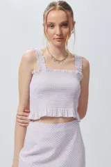 Crop top cuadrillé sin mangas con volados en la cintura.