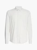 Camisa de manga larga color blanco hueso, de corte slim, con cuello tradicional y cierre frontal de botones.