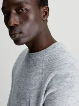Sweater de hombre Calvin Klein de tejido space dye, color gris jaspeado. Presenta cuello redondo, puños y bajo de canalé, y corte regular.