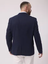 Saco color beige de piqué con cuello con solapas y bolsillos de plastrón. Mangas con coderas y bajo con abertura en espalda.