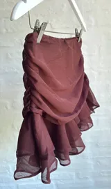 Minifalda marrón de tul con frunces laterales y volados en el ruedo.