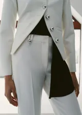 Pantalón sastrero de tiro bajo y diseño largo con botamanga acampanada, color blanco, con trabillas y cierre oculto.