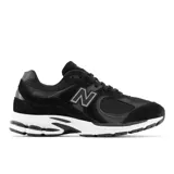 Championes urbanos New Balance modelo 2002R, color negro con detalles en gris y blanco, confeccionados en gamuza y malla, con logo "N" característico en los laterales, entresuela ABZORB y suela N-ergy.