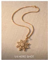 Collar de bronce con baño dorado, con cadena fina de eslabones y un dije colgante en forma de estrella de ocho puntas pavimentada con circonitas.
