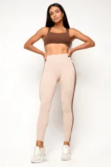 Calza deportiva de tiro alto color beige, con líneas laterales en contraste y ajuste firme.