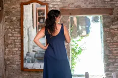 Vestido largo azul marino de lycra de algodón, con corte amplio, escote redondo al frente y escote profundo en la espalda. Tiene breteles con lazos ajustables, bolsillos y tajos laterales.