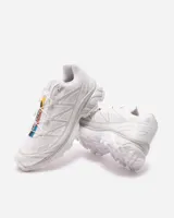 Championes Salomon modelo XT-6, color blanco con detalles sutiles en gris y acentos multicolor en el sistema de cordones. Diseñados para trail running, cuentan con una estructura resistente, suela con agarre técnico y sistema de ajuste rápido.