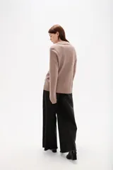 Sweater de punto color azul, con cuello polo y escote en V, de manga larga y diseño holgado.