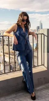 Chaleco de cuero ovino en color azul, con escote en V y cierre frontal mediante lazadas de cuero. Presenta un diseño sin mangas, de calce amplio y liviano, sin forro interior.