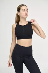 Top deportivo negro con cuello alto y cierre frontal.