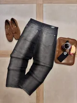 Pantalón de jean gris oscuro con corte amplio y estampado con el logo de la marca en la pierna izquierda.