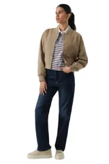 Campera tipo bomber de corte cropped, confeccionada en microgamuza color tostado. Presenta cierre frontal con botones a presión metálicos, cuello redondo y puños elásticos acanalados.