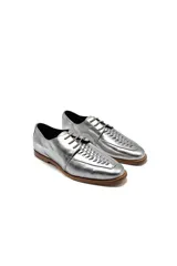Zapatos de cuero plateado con cordones y detalle de tejido trenzado en la parte delantera.