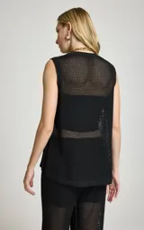 Musculosa de punto negro Le Lis Blanc, de corte recto, escote redondo, sisas amplias y tejido calado con transparencia. Presenta un diseño asimétrico con superposición frontal y detalle de anillo metálico en el lateral.