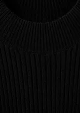 Vestido corto de punto acanalado con diseño peplum, cuello redondo y mangas largas. Presenta un ajuste entallado en el torso que se abre en la cintura con un corte evasé.