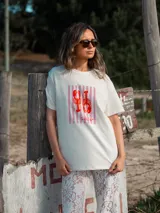 Remera color crudo de algodón, corte oversize y mangas cortas. Estampado frontal con una langosta roja sobre un fondo de rayas verticales rosas y la palabra "Lobster" debajo.