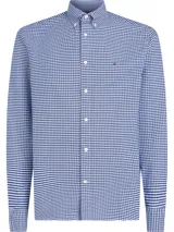 Camisa de corte regular confeccionada en algodón Oxford, con estampado de cuadros Vichy en color azul y blanco. Cuenta con cuello abotonado, cierre frontal de botones y mangas largas con puños ajustables. Incorpora un pequeño logo bordado de la marca en el pecho.