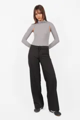 Body gris de tejido de punto con cuello alto y mangas largas. Presenta aberturas en los hombros, broches snap en la entrepierna y elástico interno en el contorno de tiro.