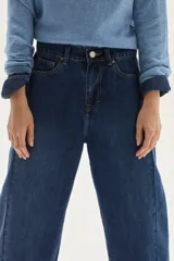 Jean de mujer color azul oscuro, tiro alto, con corte barrel y pierna ancha y ligeramente curva. Confeccionado en 100% algodón.