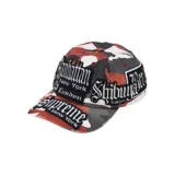 Gorra de béisbol con diseño de camuflaje en tonos rojos, blancos y negros, decorada con múltiples parches bordados que incluyen nombres de ciudades como Manhattan, London, Shibuya y Tokyo, además de la marca Supreme.
